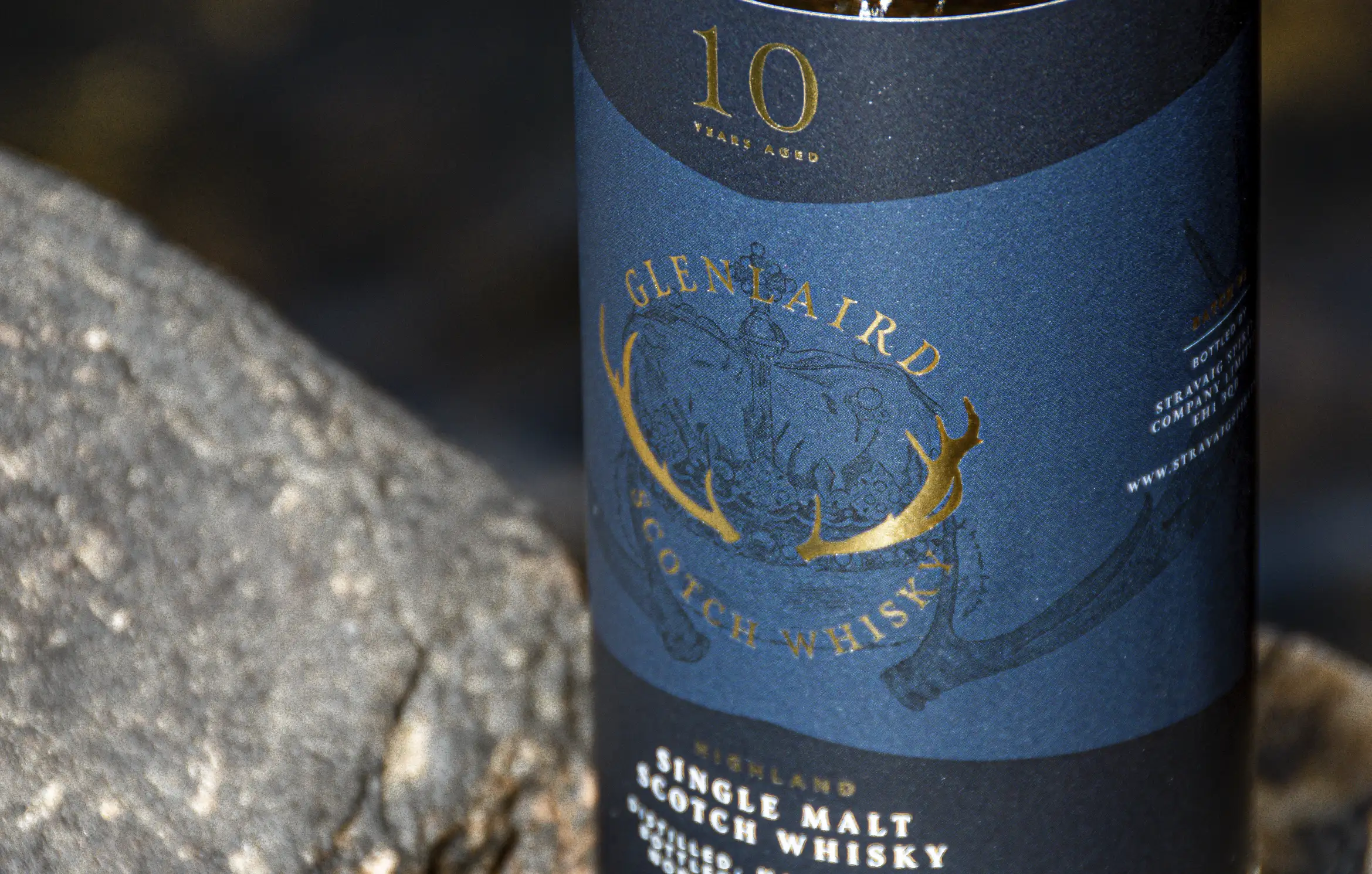 Glelaird Header 1 Close-up of Glenlaird's whisky label showcasing a hand-illustrated crown with intricate details and gold foil printing, highlighting the luxurious and artisanal quality of the packaging design.