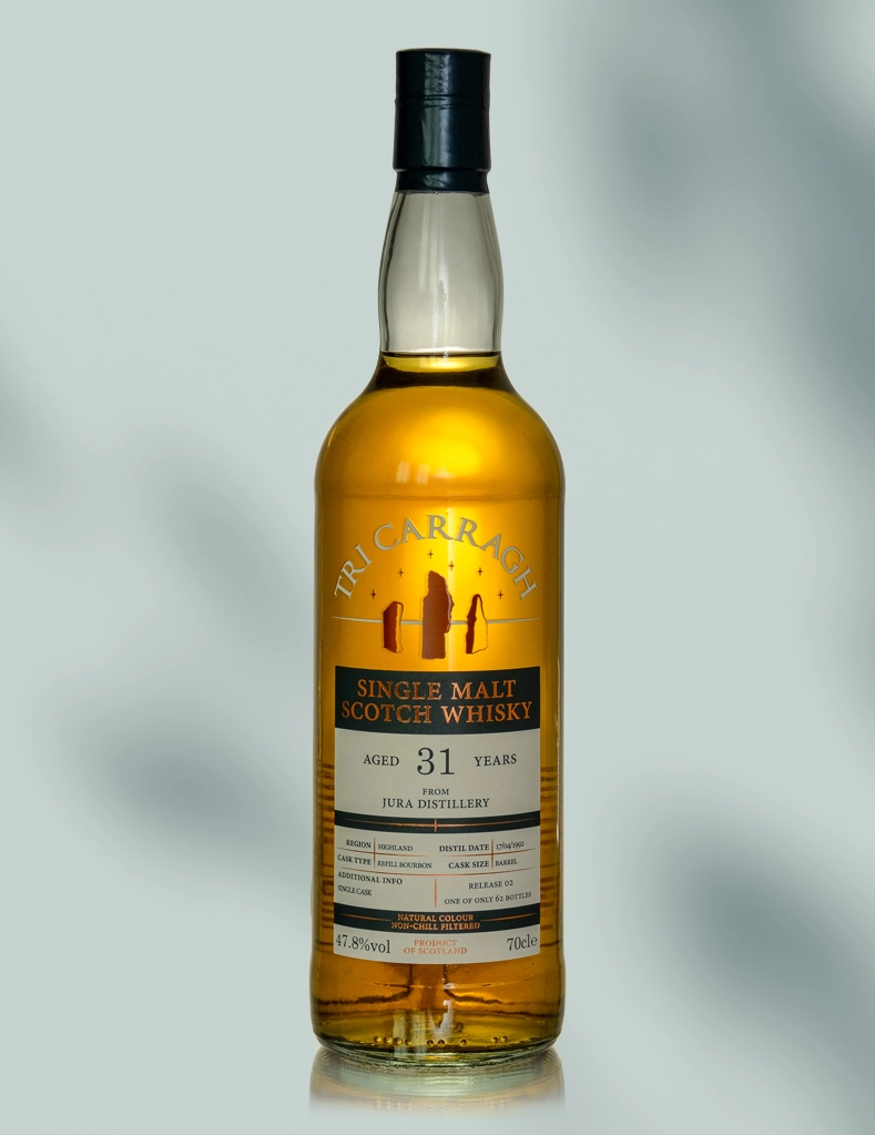 A bottle off Tri Carragh 31 year old whisky shot on a light shadowed background