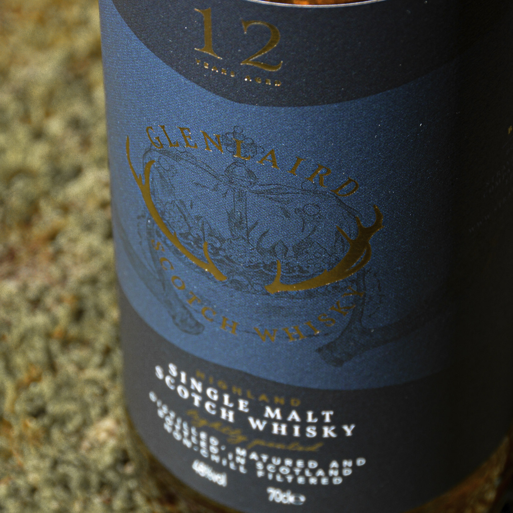Crown close up Close-up of Glenlaird's whisky label showcasing a hand-illustrated crown with intricate details and gold foil printing, highlighting the luxurious and artisanal quality of the packaging design.