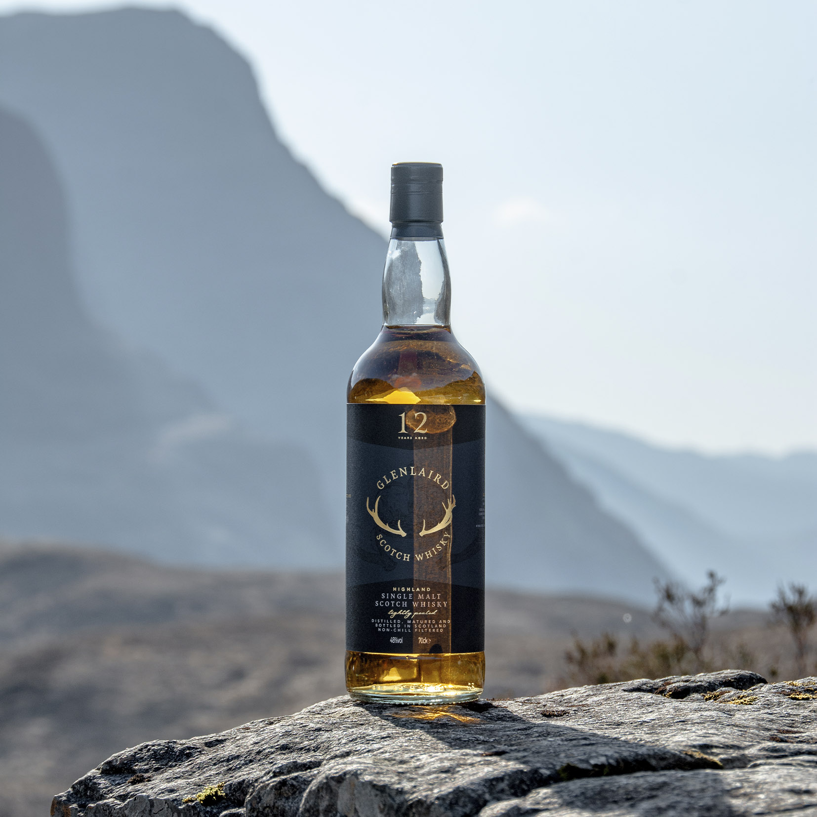 Glenlaird Rocky Product photo of Glenlaird whisky shot in the Highlands, featuring a bottle of the single-malt Scotch whisky set against a backdrop of rolling hills. The scenic landscape emphasizes the whisky's Scottish heritage. Photography by Studio Hart.